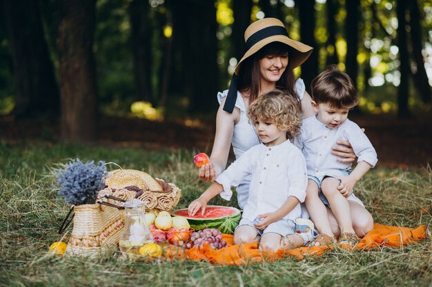 Madre con sus hijos haciendo un picnic en el bosque