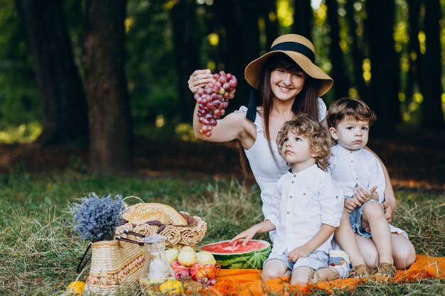 Madre con sus hijos haciendo un picnic en el bosque