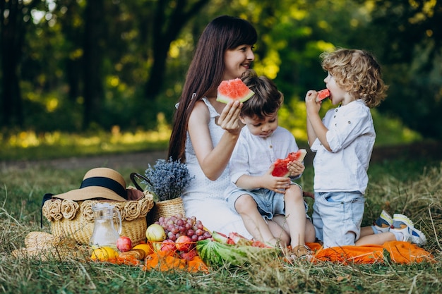 Madre con sus hijos haciendo un picnic en el parque