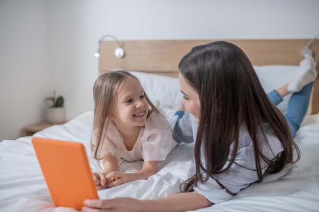 Madre con la tableta y su hija alegre