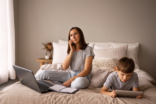 Foto gratuita madre de tiro completo hablando por teléfono