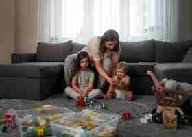 Foto gratuita madre de tiro completo con niños en casa.