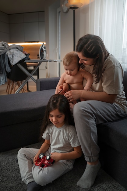 Foto gratuita madre de tiro completo con niños en casa.