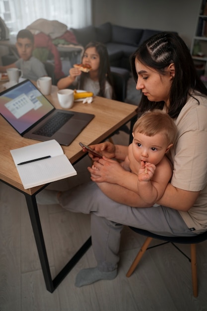 Foto gratuita madre de tiro completo con niños en casa.