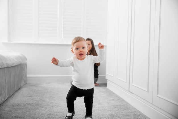 Madre de tiro completo viendo caminar al niño