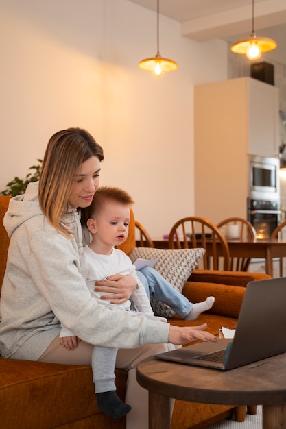 Foto gratuita madre de tiro medio trabajando de forma remota