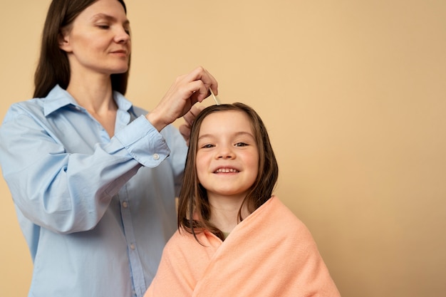 Madre de tiro medio usando un peine para el cabello