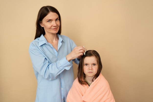 Madre de tiro medio usando un peine para el cabello