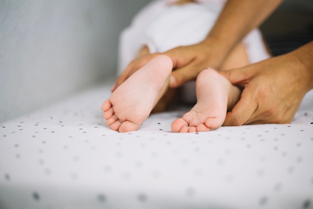 Madre tocando las piernas del bebé