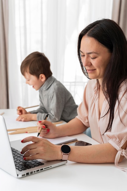 Madre trabajando en casa con niño