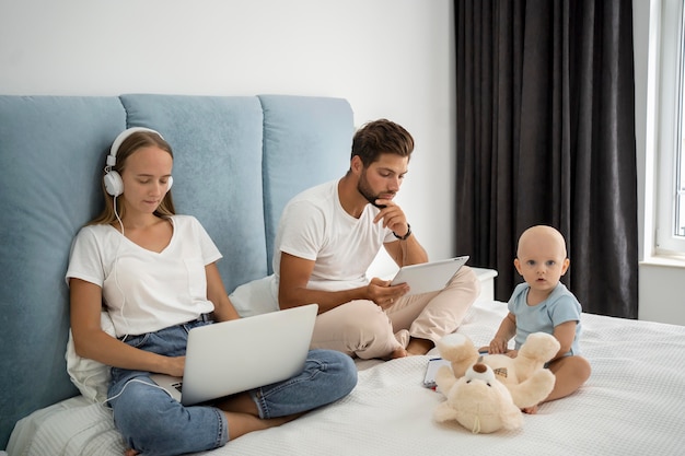 Madre trabajando en la computadora portátil desde casa durante la cuarentena con el niño