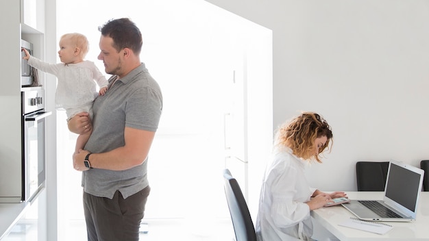 Madre trabajando en la computadora portátil en casa