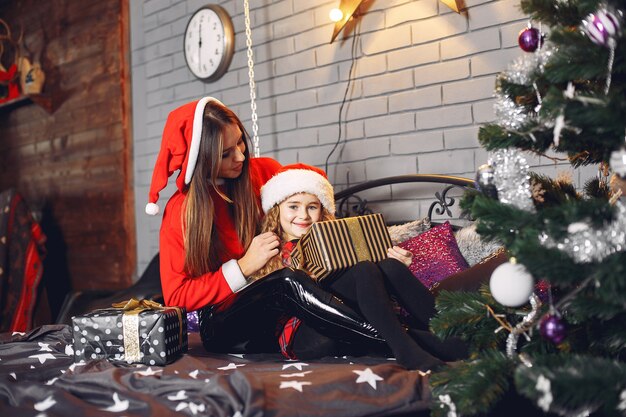 Madre en traje de santa con linda hija en casa