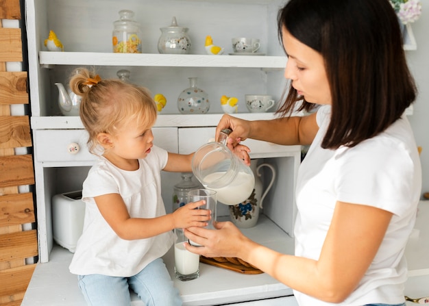 Madre vertiendo leche para su encantadora hija