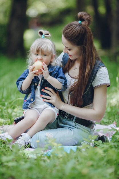 Madre viendo a su hija mientras se come una manzana