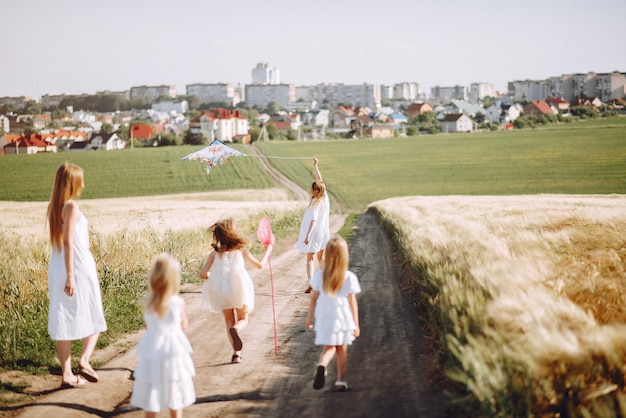 Madres con hijas jugando en un campo de otoño