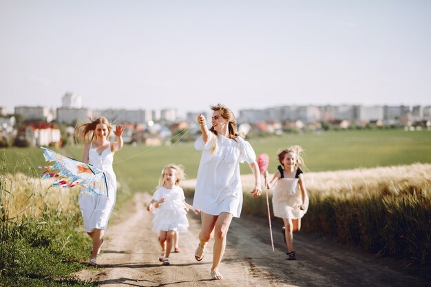 Madres con hijas jugando en un campo de otoño