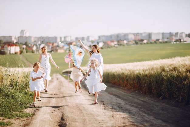 Madres con hijas jugando en un campo de otoño