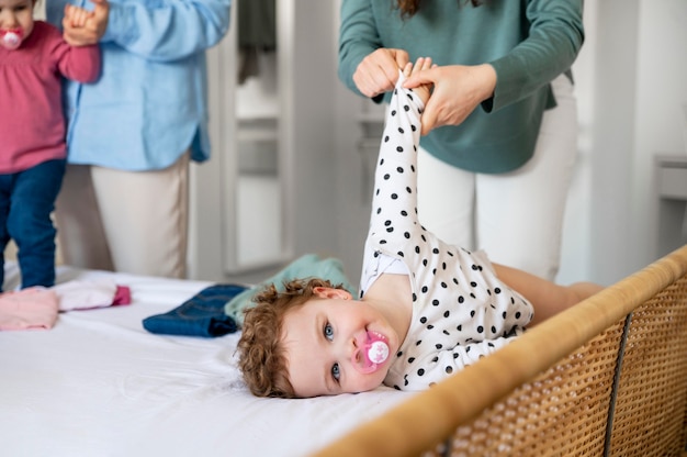 Madres LGBT en casa cambiando la ropa de sus hijos