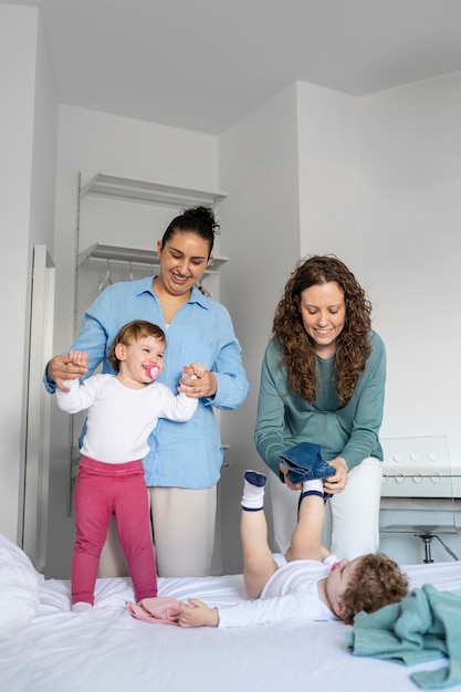 Madres LGBT en casa en el dormitorio con sus hijos.