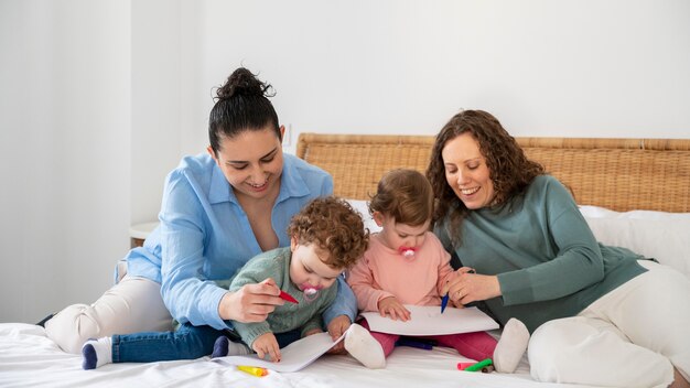 Madres LGBT en casa en el dormitorio con sus hijos