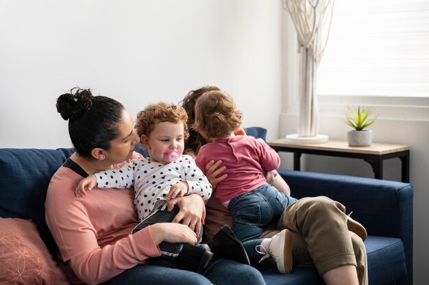 Madres LGBT en casa en el sofá con niños