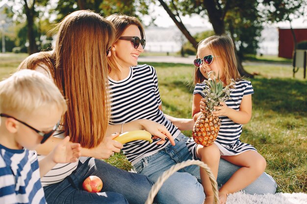 Madres con niños jugando en un parque de verano