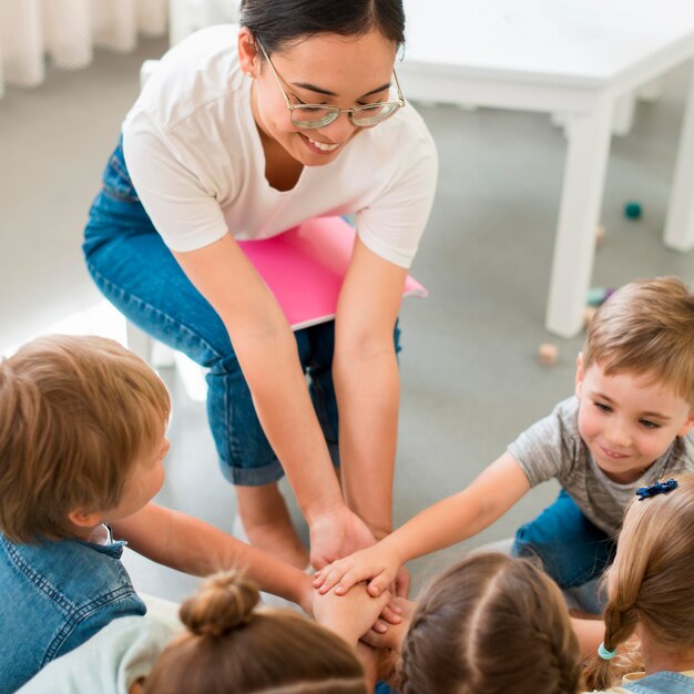 Maestra de alto ángulo jugando con sus alumnos