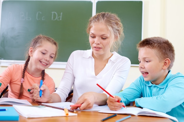 Foto gratuita maestra ayudando a los estudiantes en clase