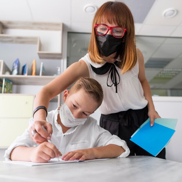 Maestra ayudando a su alumno en clase