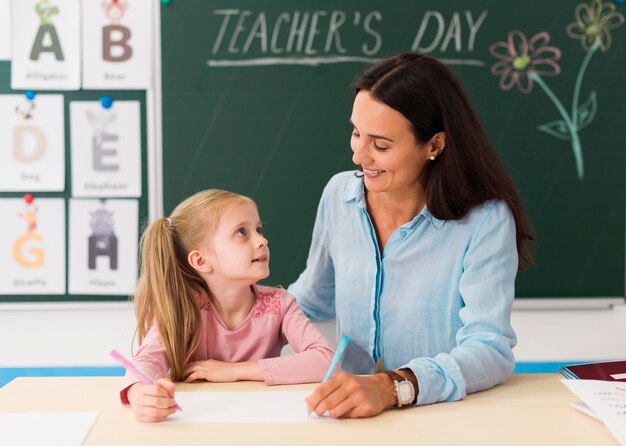 Maestra mirando a su pequeña alumna