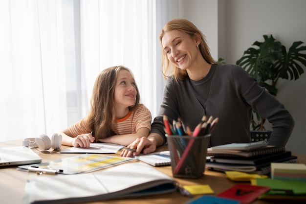 Maestra y niña sonriente de tiro medio