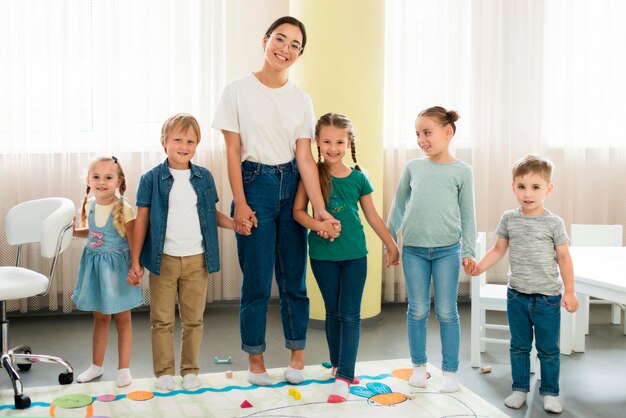 Maestra y niños posando juntos