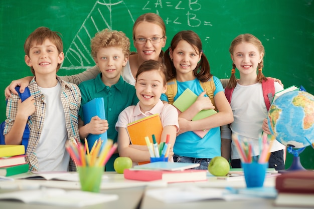 Maestra orgullosa con sus estudiantes de primaria