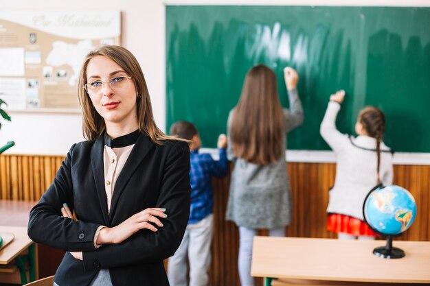 Maestra de pie en el fondo del aula