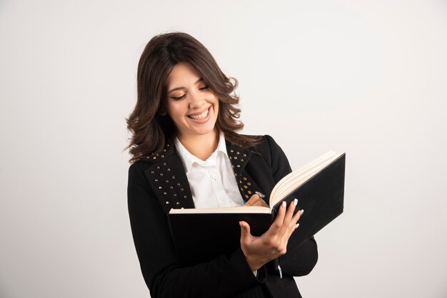 Maestra positiva escribiendo notas para su clase.