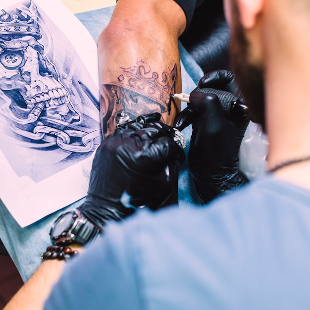 Maestro haciendo tatuaje con hierro