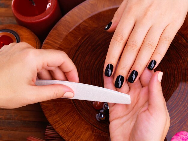 Maestro manicurista hace manicura en manos de mujer - concepto de tratamiento de spa