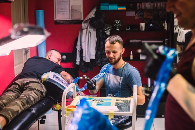 Maestros y cliente en estudio de tatuajes