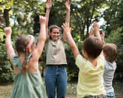 Foto gratuita maestros y niños haciendo ejercicio al aire libre