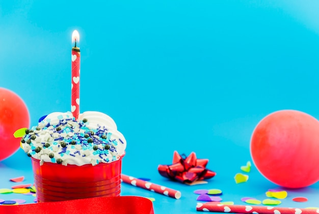 Foto gratuita magdalena de cumpleaños con una vela y globos