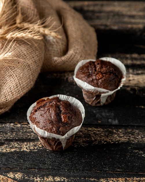 Foto gratuita magdalenas de chocolate y trigo en la mesa