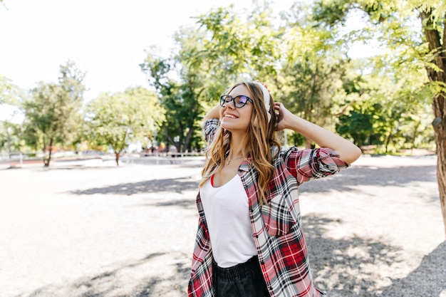 Magnífica chica en ropa casual riendo en primavera. Mujer rubia complacida disfrutando del fin de semana de verano.