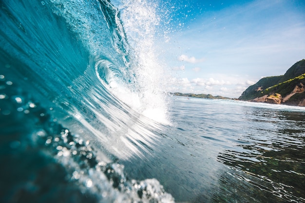 Magnífica vista de una ola con rocksnin el fondo capturado en Lombok, Indonesia