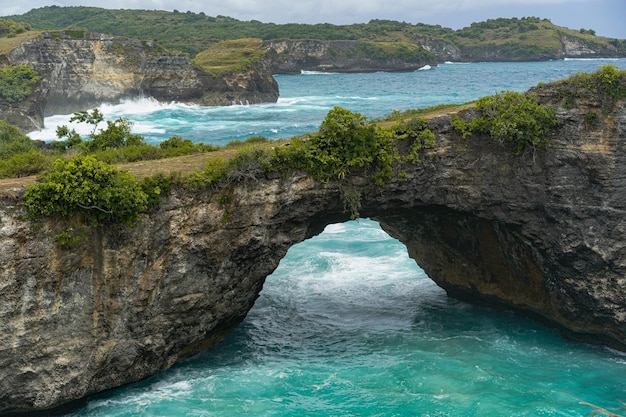 Magnífica vista de rocas naturales únicas y formación de acantilados en la hermosa playa conocida como la playa angel's billabong ubicada en el lado este de la isla de nusa penida, bali, indonesia. vista aérea.