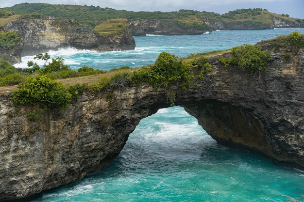 Magnífica vista de rocas naturales únicas y formación de acantilados en la hermosa playa conocida como la playa Angel's Billabong ubicada en el lado este de la isla de Nusa Penida, Bali, Indonesia. Vista aérea.