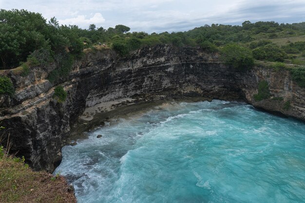 Magnífica vista de rocas naturales únicas y formación de acantilados en la hermosa playa conocida como la playa Angel's Billabong ubicada en el lado este de la isla de Nusa Penida, Bali, Indonesia. Vista aérea.