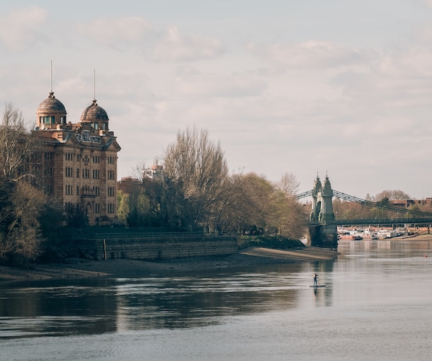 Magnífico castillo antiguo capturado por un puente sobre un hermoso río en un día nublado