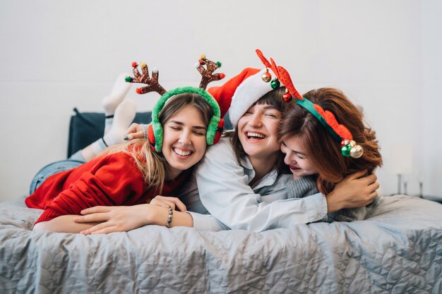 Magníficos amigos sonrientes divirtiéndose y disfrutando de la fiesta de pijamas