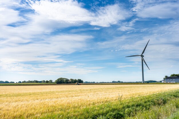 Majestuosa vista del paisaje de la tierra con un molino de viento para generar electricidad bajo un cielo nublado